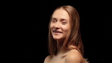 Diş telleri ve güzel saç rengi ile kız döner kamera ve gülüyor. Siyah