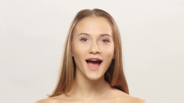 Mladá dívka s držáky na zuby, hodinky a blikat. Bílá — Stock video