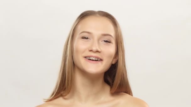 Eine glückliche Frau mit Klammern an den Zähnen schaut zu und lacht. weiß — Stockvideo