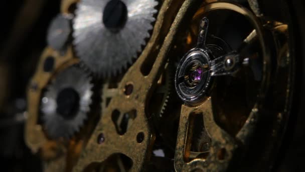 Moving metal gears inside working watch mechanism. Close up