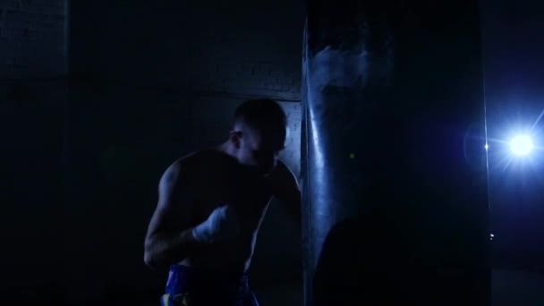 Jóvenes entrenando con una bolsa de boxeo en un club de boxeo. Movimiento lento . — Vídeos de Stock