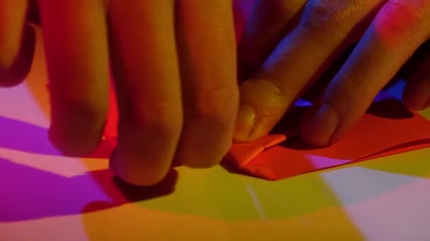 Κορίτσι κάνει origami χαρτί από ροζ χάρτινο. Κινηματογράφηση σε πρώτο πλάνο — Αρχείο Βίντεο
