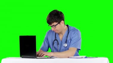 Kızgın doktor masada poz. Yeşil ekran