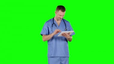 Bir tablet kullanarak gülümseyen doktor. Yeşil ekran