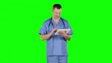 Doktor bir tablet kullanır ve başparmağını gösterir. Yeşil ekran