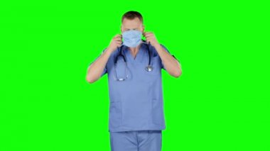 Doktor yüzüne tıbbi bir bandaj takıyor. Yeşil ekran