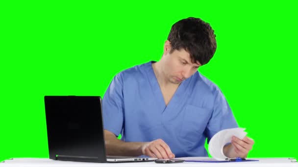Ο γιατρός χρησιμοποιεί έναν υπολογιστή και μιλάει στο τηλέφωνο. Πράσινη οθόνη — Αρχείο Βίντεο