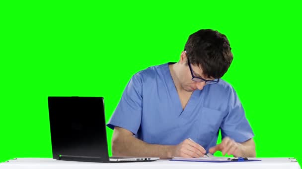 Médico varón escribiendo en el escritorio en su oficina haciendo la prescripción. Pantalla verde — Vídeo de stock