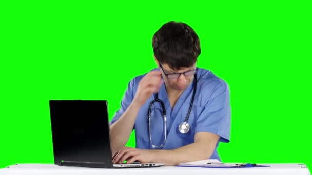 Φιλικός, ευτυχισμένος άντρας γιατρός στο γραφείο χρησιμοποιώντας φορητό υπολογιστή. Πράσινη οθόνη — Αρχείο Βίντεο