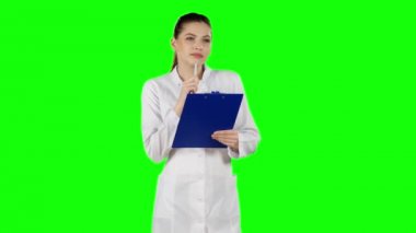 Hemşire ya da genç doktor sağlık dosyası panoya yazma. Yeşil ekran