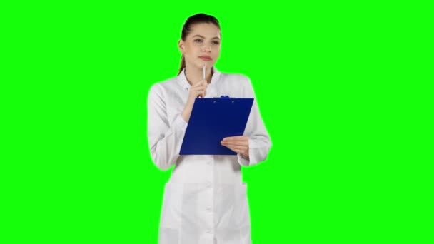 Enfermera o joven médico escribiendo en portapapeles de archivos médicos. Pantalla verde — Vídeos de Stock