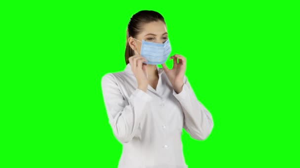 Młoda atrakcyjna kobieta stawiając na zdrowie maski. Zielony ekran — Wideo stockowe