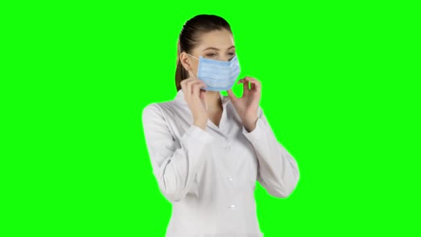 Jonge aantrekkelijke vrouw gezondheid masker in te zetten. Groen scherm — Stockvideo