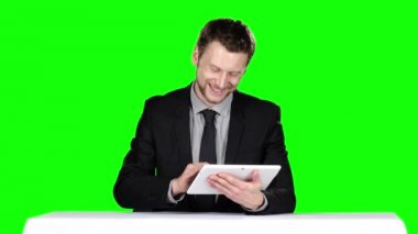 Masada oturan işadamı dizüstü bilgisayar kullanıyor. Yeşil ekran