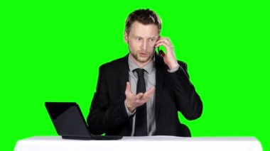 İşadamı oturup telefonda konuşuyor. Yeşil ekran