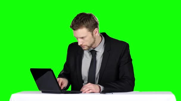 Empresário sentado em uma mesa e usando notebook e ligando para o telefone. Tela verde — Vídeo de Stock