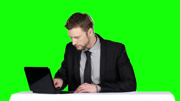 Zakenman zit aan tafel en maakt gebruik van notebook. Groen scherm — Stockvideo