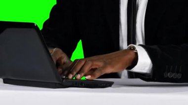 Young businessman working on his laptop at his desk. Green screen