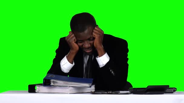 Бізнесмен сидить за столом і тримає голову. Зелений екран — стокове відео