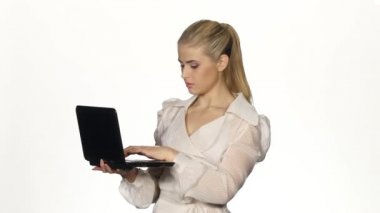 Young businesswoman works on notebook and smiles. White