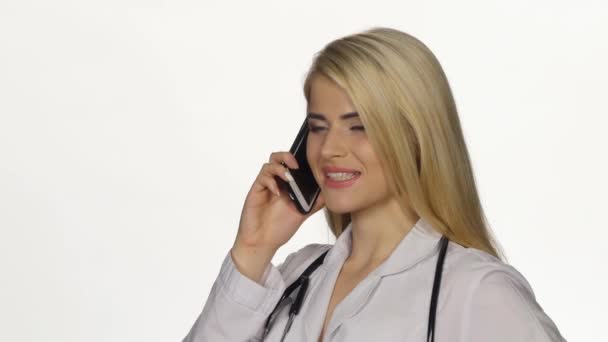 Kadın doktor cep telefonuyla konuşuyor. Beyaz. Closeup — Stok video