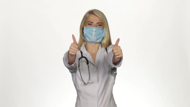 Female doctor making thumbs up sign. White — Stock Video