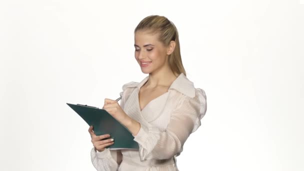 Young, pretty businesswoman writing notes. White — ストック動画