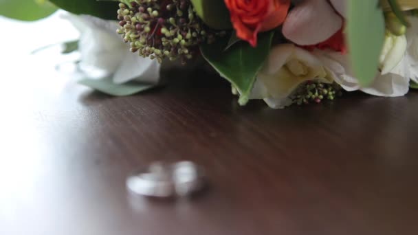 Свадебные кольца и букетики цветов, динамическая смена фокуса — стоковое видео