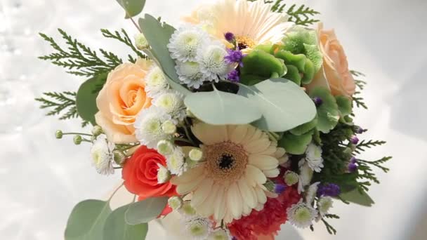 Ramo de flores diferentes con hojas verdes en la mesa blanca — Vídeos de Stock