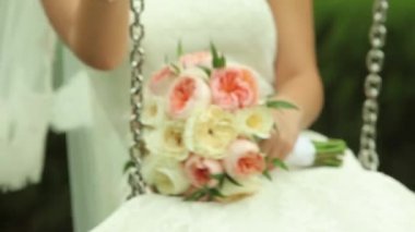 Salıncaklar sallanan ve onun buket çiçek tutan gelin