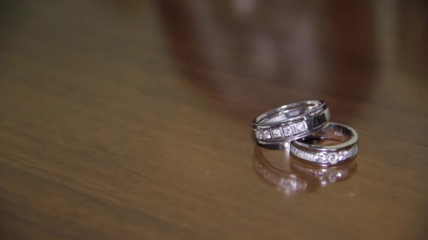 Anillos de boda dorados en la mesa, cambio dinámico de enfoque . — Vídeo de stock