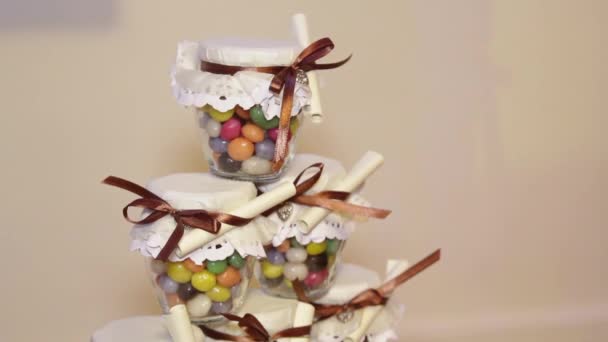 Caramelos multicolores en frascos de vidrio para invitados de fiesta de bodas . — Vídeos de Stock