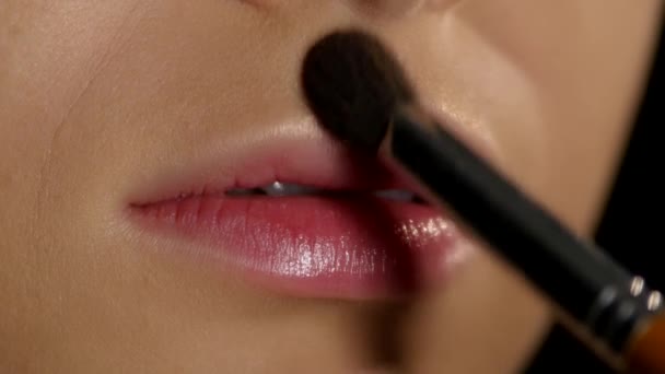 Aplicando iluminador en las esquinas de los labios. Maquillaje . — Vídeos de Stock