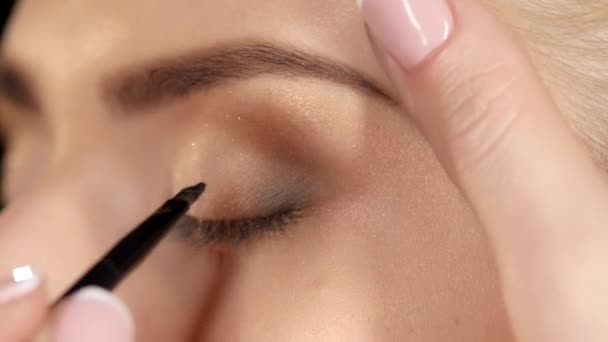 Professionele make-up artiest die eyeliner toepast. Close-up — Stockvideo