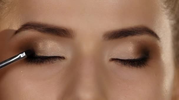 Maquillage des yeux femme appliquant de la poudre de fard à paupières. Belle visage de femme. Gros plan — Video