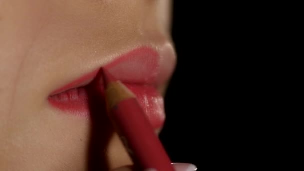Artista de maquillaje aplicando delineador de labios a los labios modelo. Negro. Primer plano. — Vídeos de Stock