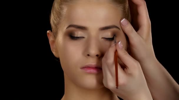 Professionele make-up. Zijaanzicht van de oogschaduw applicatie met kwast. Zwarte. Close-up — Stockvideo