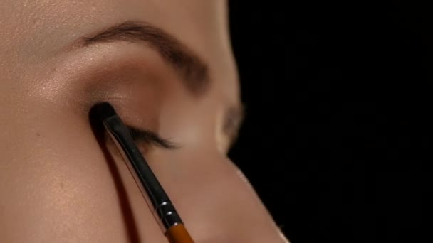 Woman applying make up to woman. Black. Closeup