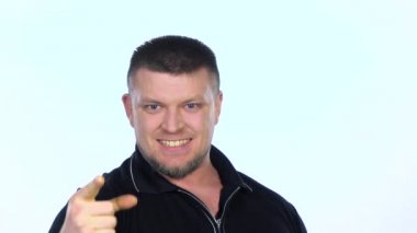 Young beautiful happy man stare into camera, emphatically shows forefinger ahead. White. Slow motion