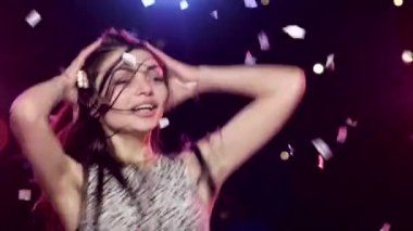 Kaygısız kız disko ışıkları ve glitter konfeti karşı dans ediyor