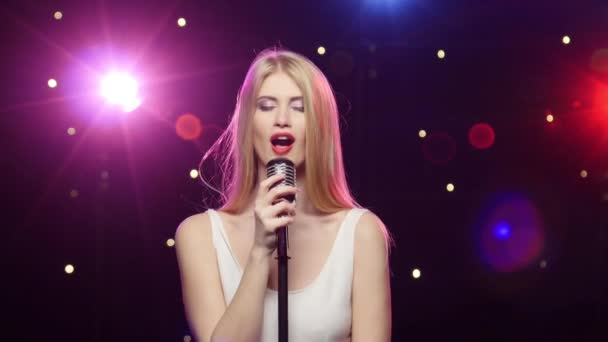 Fille blonde chantant dans un effet d'éclairage stroboscopique microphone rétro — Video