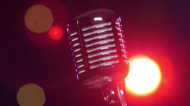 Retro parlak mikrofon bulanık yanıp sönen ışıklara karşı yavaş döner
