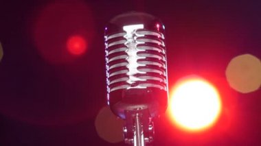 Bulanık yanıp sönen ışıklara karşı dönen retro parlak mikrofon. Close