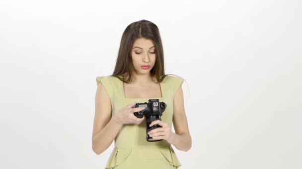 Ragazza guarda i risultati del servizio fotografico sullo schermo della fotocamera. Bianco — Video Stock