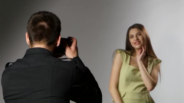 Una chica y un fotógrafo en el estudio. Punto de luz — Vídeo de stock