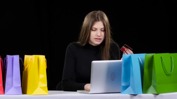 Meisje doet winkelen online met behulp van haar creditcard en laptop. Zwarte — Stockvideo