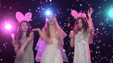 Kız arkadaşlar bekarlığa veda partisinde dans edip şampanya içiyorlar. Yavaş çekim