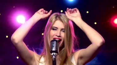 Retro mikrofon ve elleri yukarı ile Şarkıcı kadın. Yavaş çekim