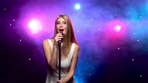 Chica cantando en micrófono retro con efecto humo. Movimiento lento — Vídeo de stock