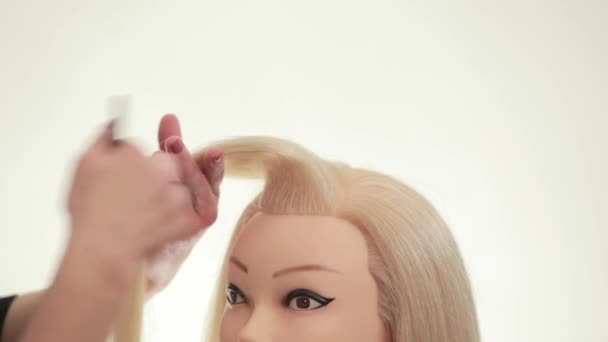 Master demonstrates styling on a mannequin. Mannequin of blonde. White. Close up — Stock Video